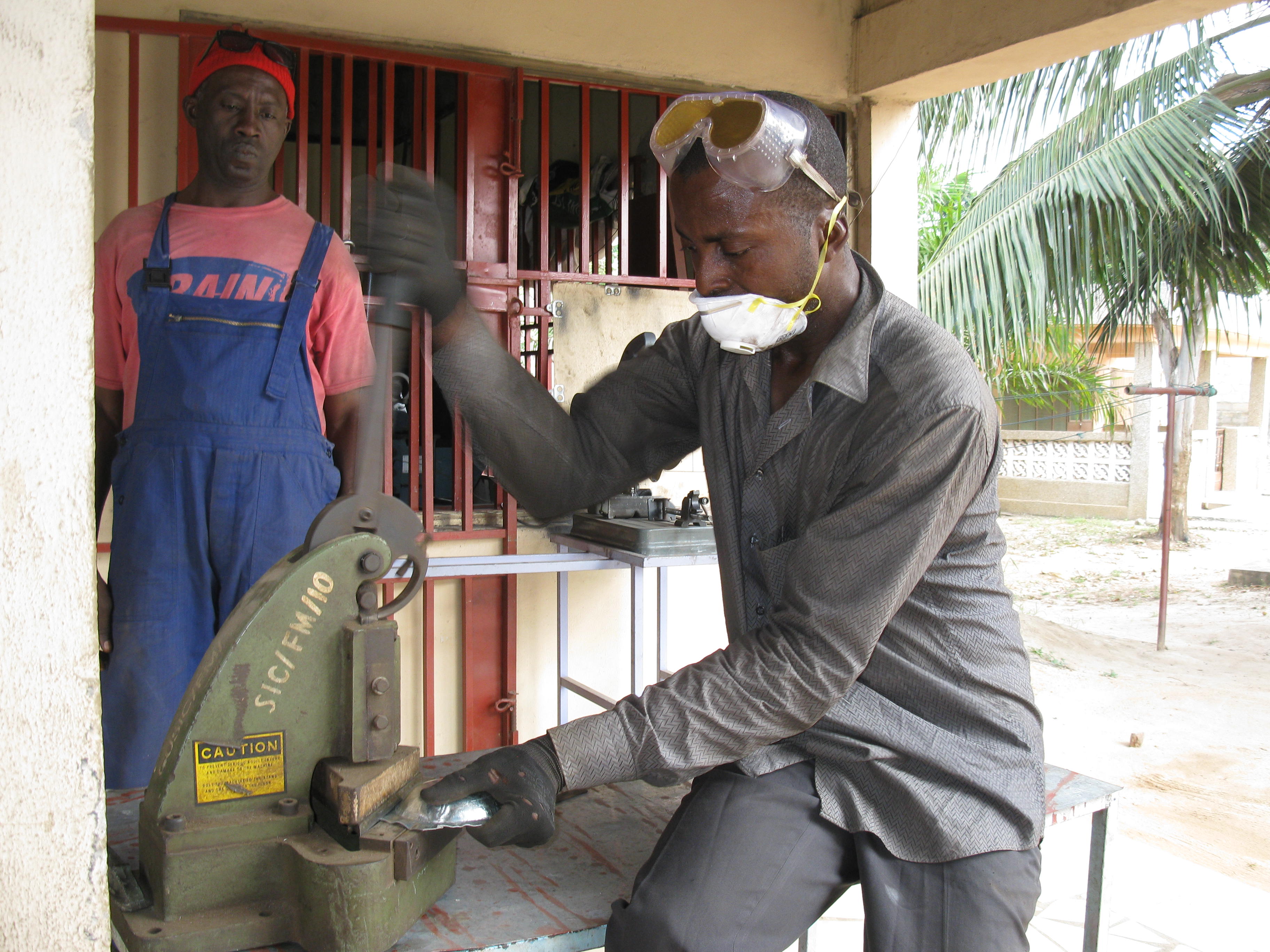 A Ghanaian Metal Fabricator cutting a plate