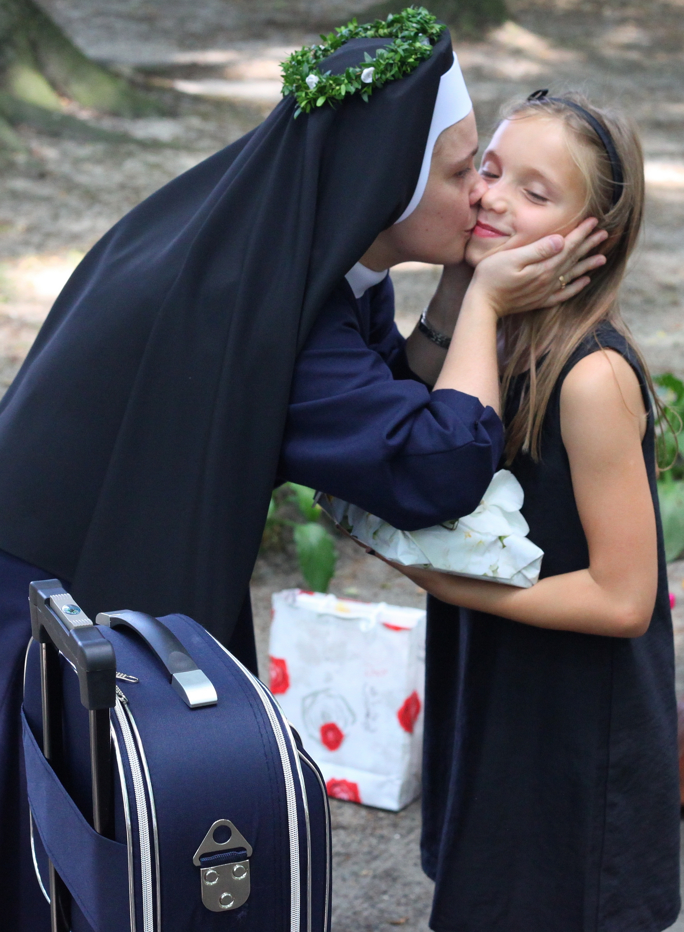 a nun kissing a girl who has just greeted her