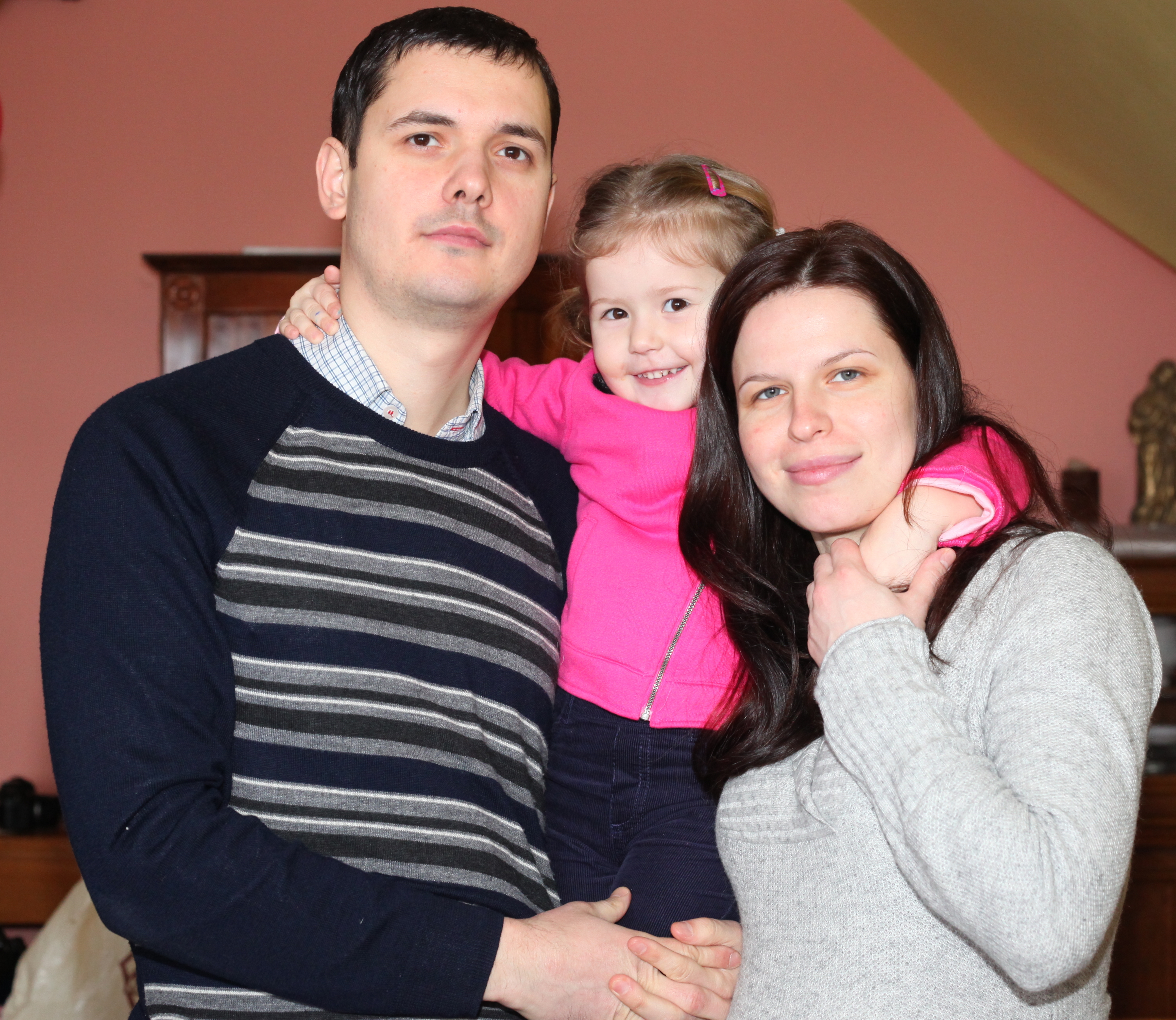 a pregnant beautiful brunette Catholic woman with her husband and daughter, picture 8