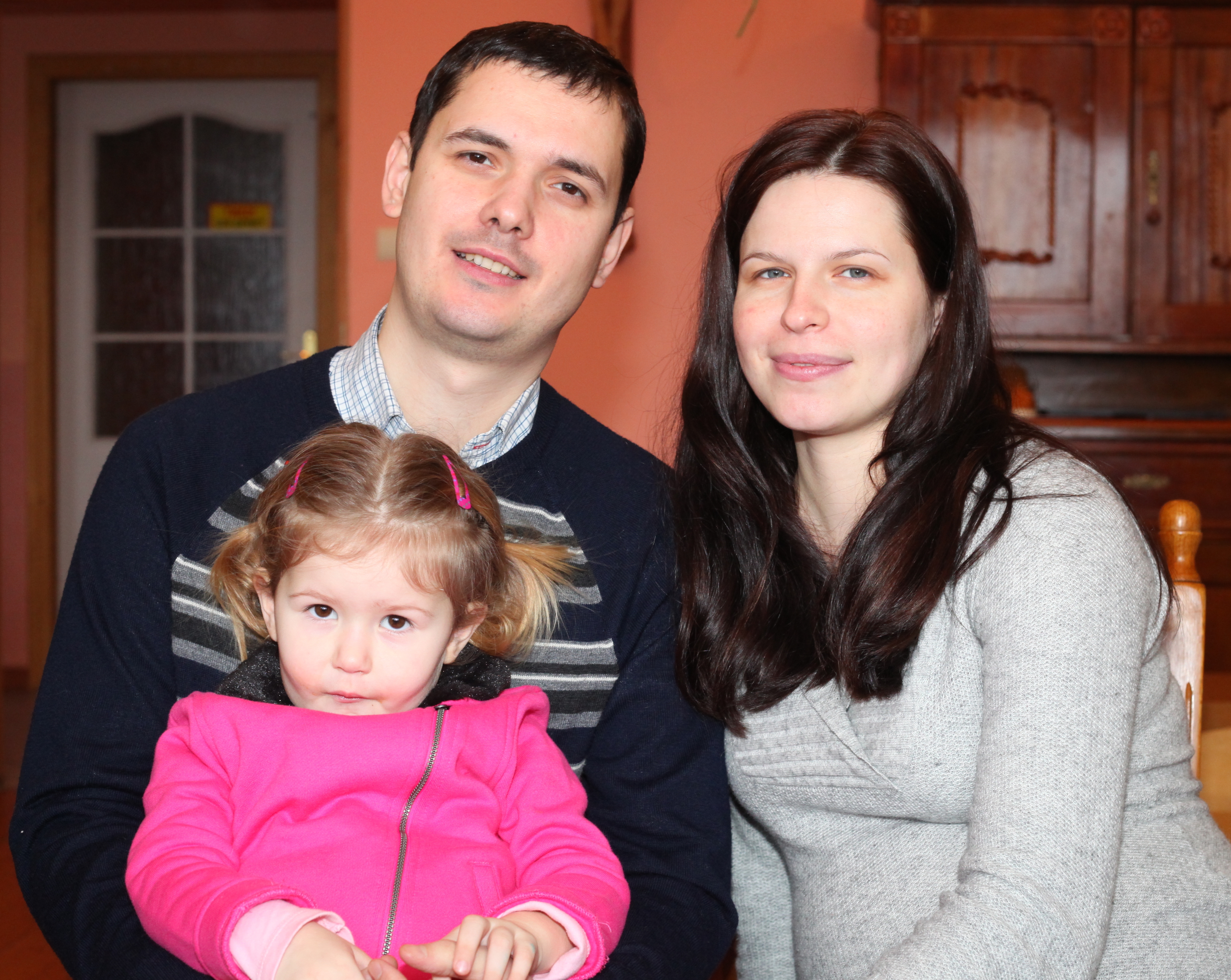 a pregnant beautiful brunette Catholic woman with her husband and daughter, picture 14