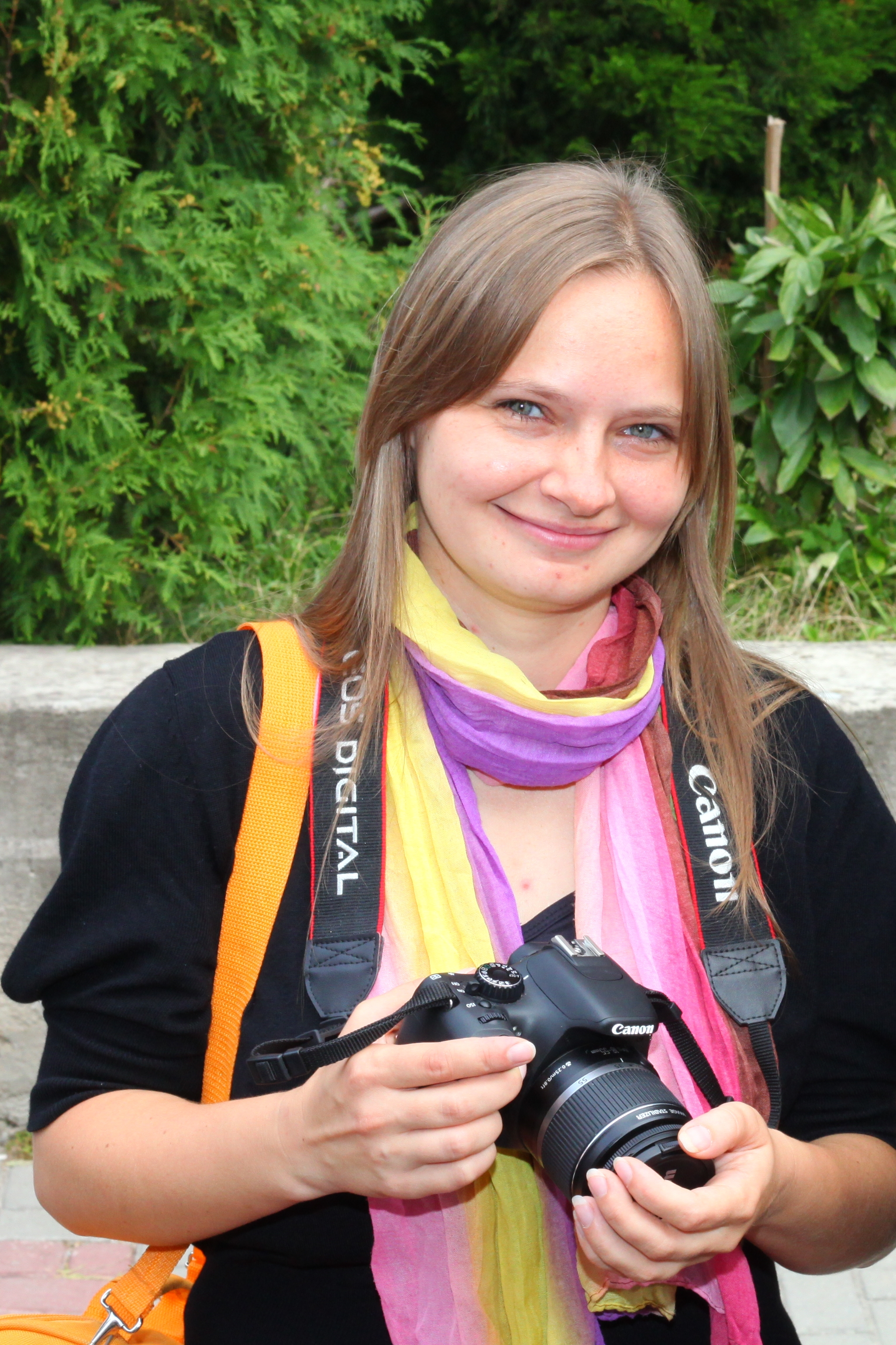 A pretty fair-haired girl / chick / young woman (journalist) with a Canon camera, photo 2.