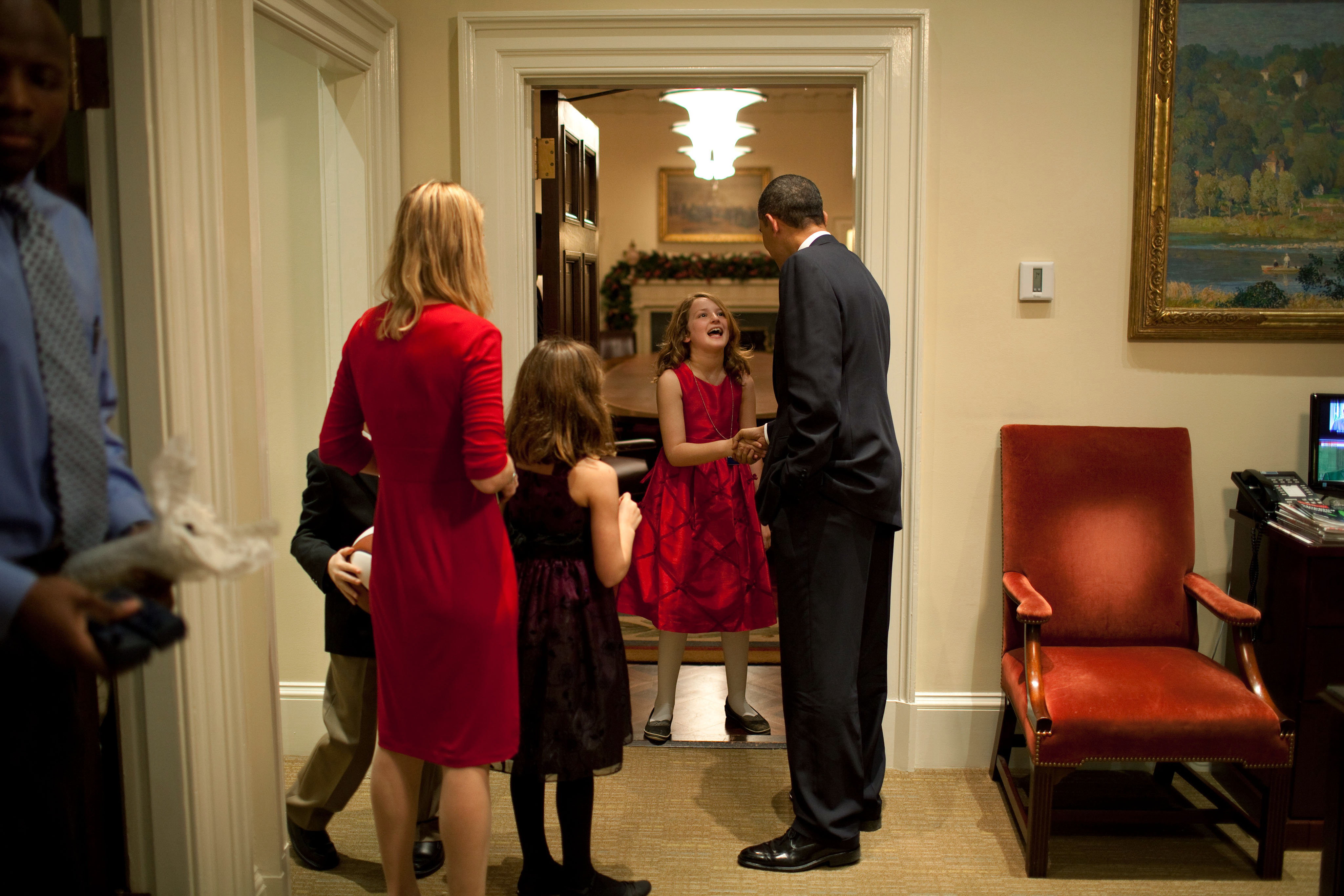 Barack Obama greets a family in the Oval Office secretary office