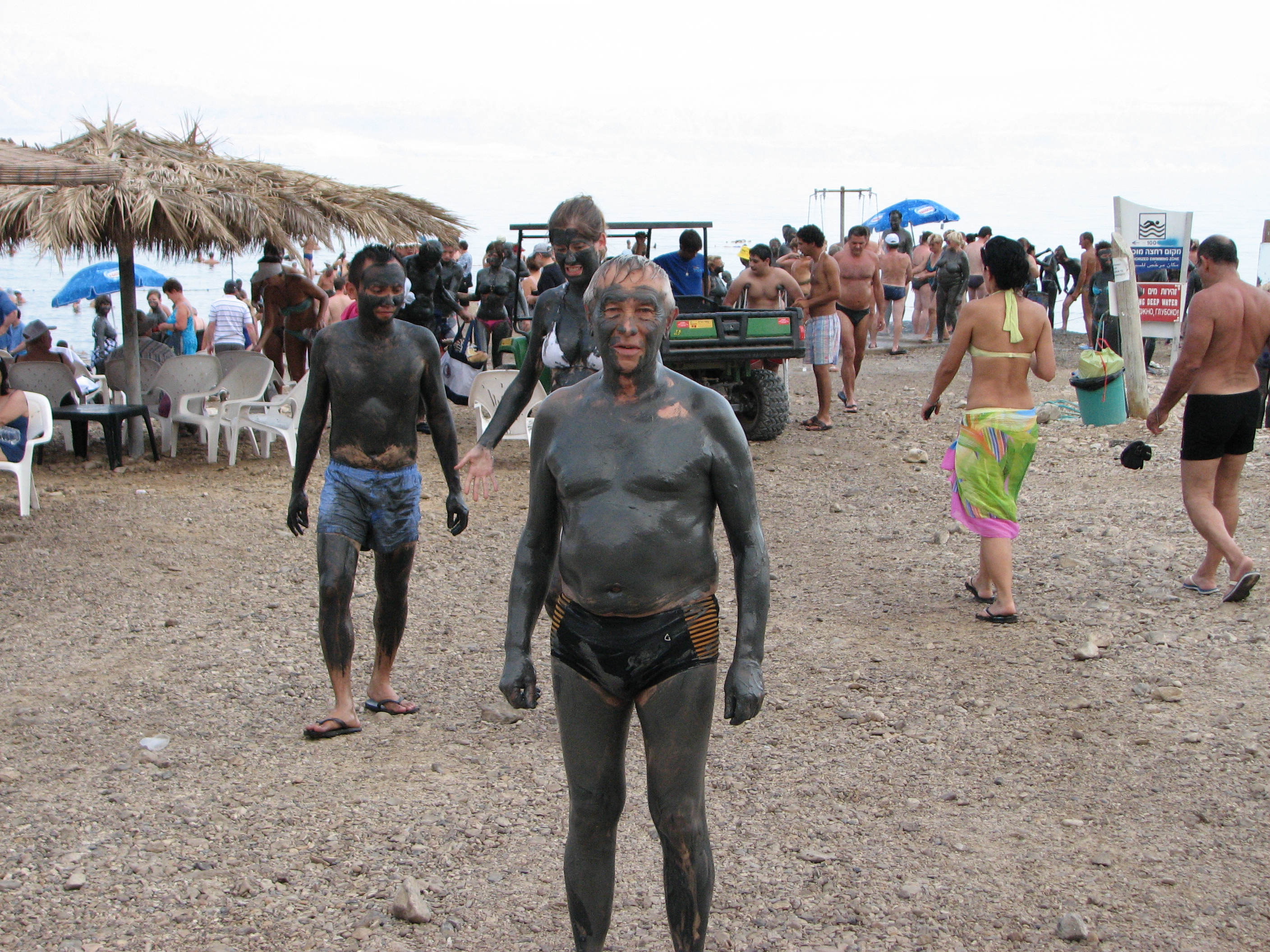 People smeared with dirt on the Dead Sea shore, Israel, 2011