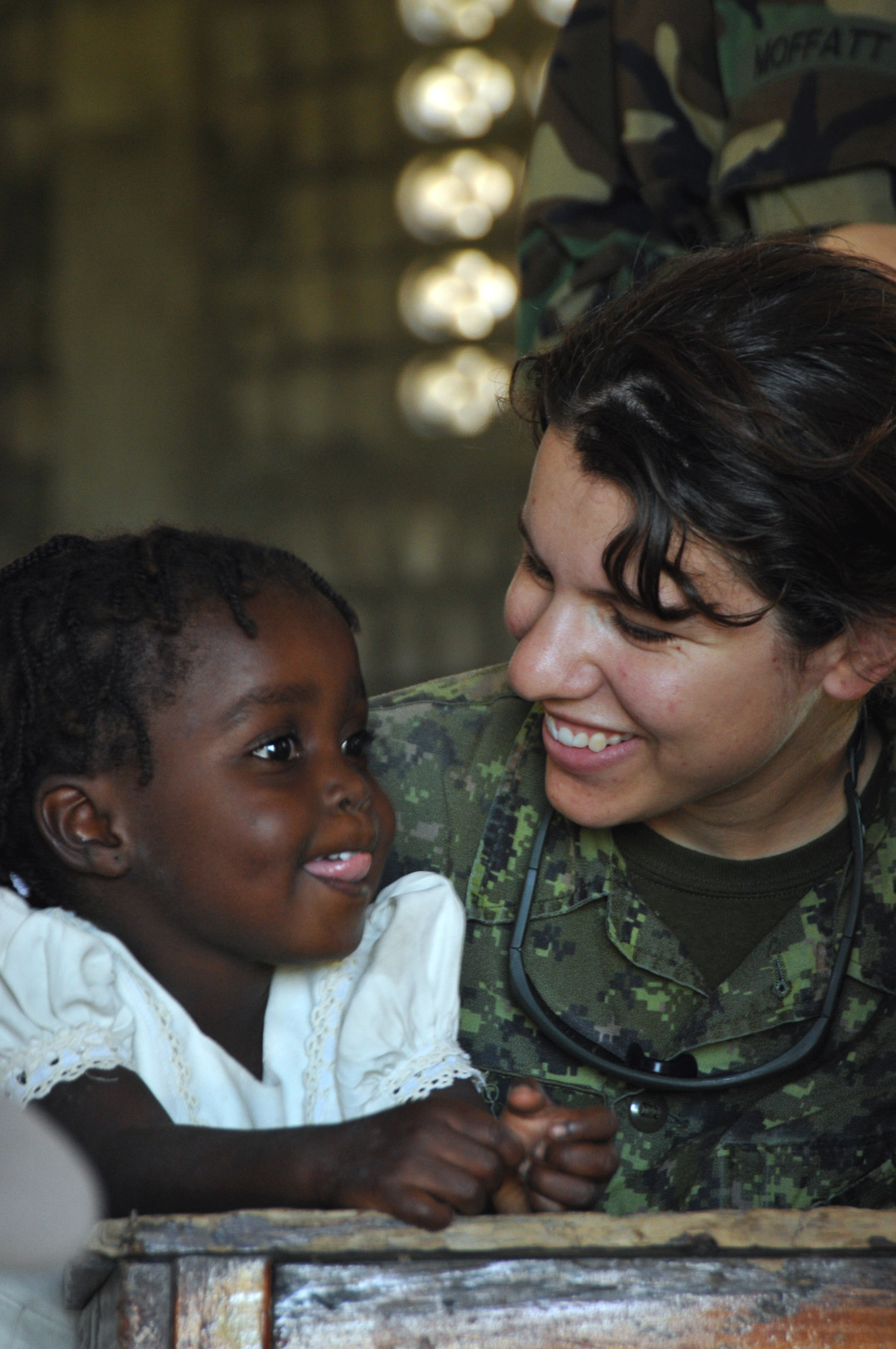 Friendly Canadian medic examines a smiling Haitian earthquake survivor