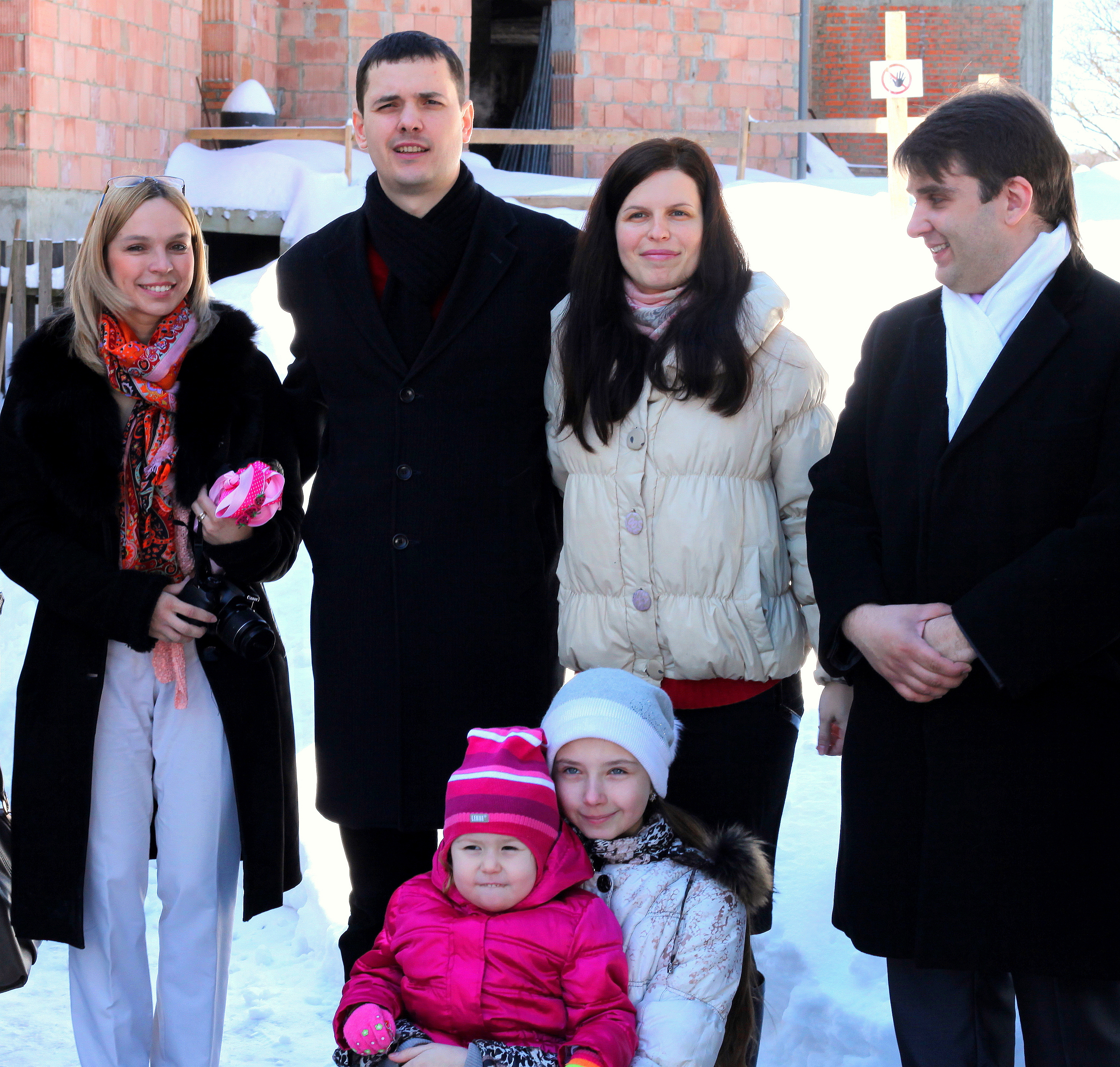 parents and godparents after the baptism of their baby-daughter in a Catholic Church