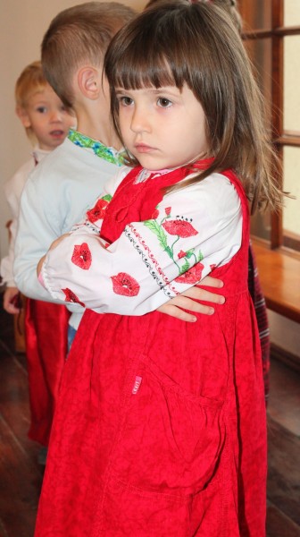 a beautiful amazing cute charming Catholic child girl in a red dress in a Church, photo 1