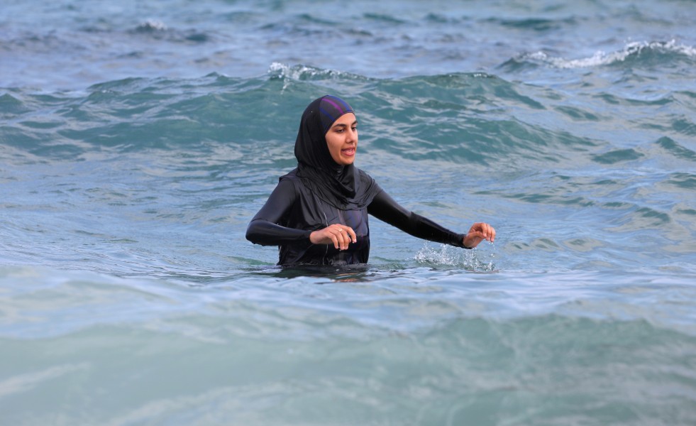a fully-clothed woman swimming in the Mediterranean Sea in August 2013, photo 1/2