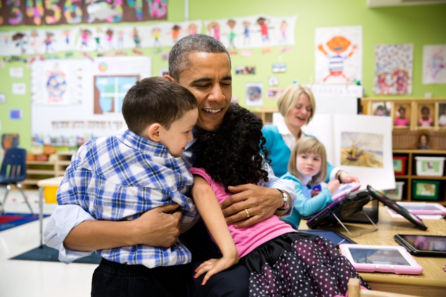 Barack Obama hugs students during a visit to a pre-kindergarten classroom, 2013