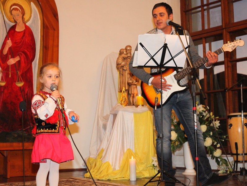 a Catholic father with his daughter performing in a Catholic kindergarten