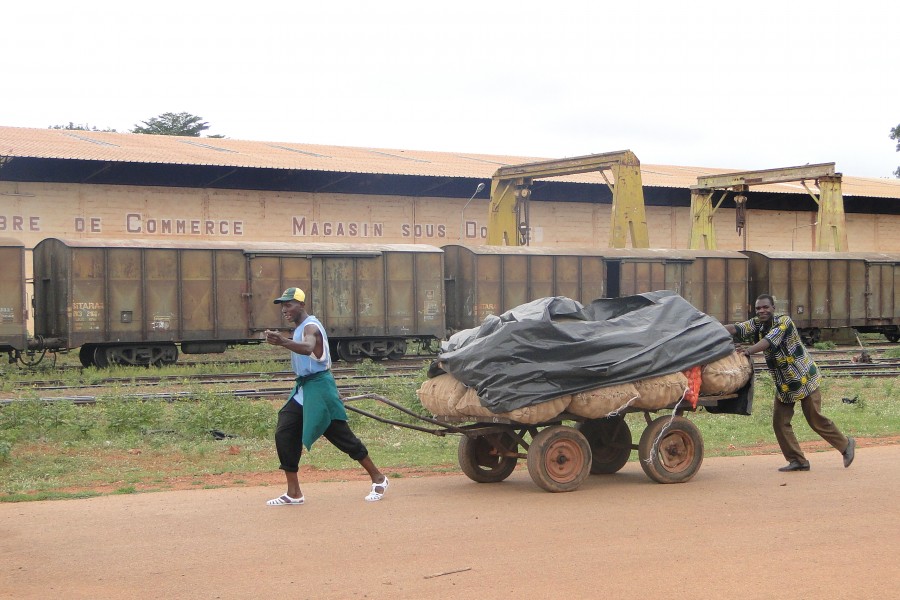Men Push a Cart Past the Railway Station - Bobo-Dioulasso - Burkina Faso