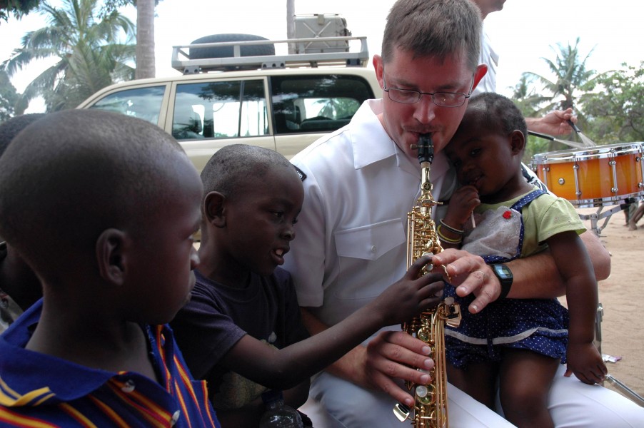 US Navy 070908-N-3255B-007 Musician 3rd Class Jeremy Saunders, of the U.S. Navy Europe-Africa rock band, Topside, entertains children at Yatima Group Orphanage