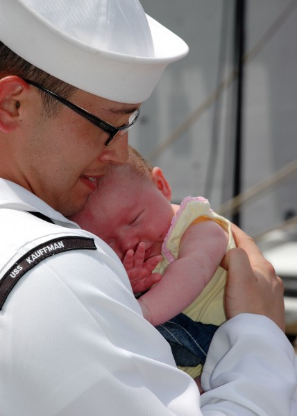 US Navy 090805-N-5292M-957 Information Systems Technician 2nd Class Michael Cao, assigned to the guided-missile frigate USS Kauffman (FFG 59), holds his one-month-old daughter for the first time