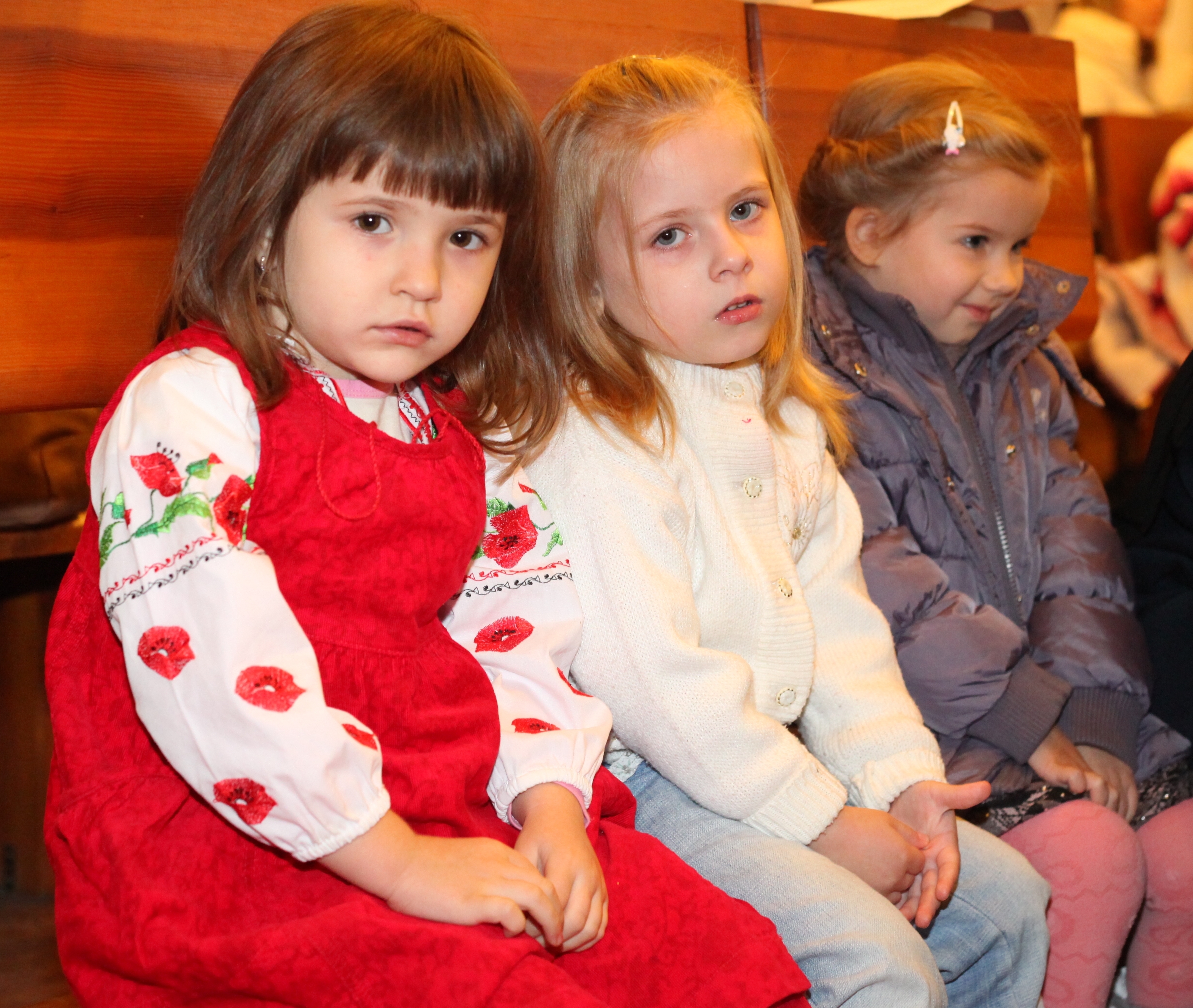 three cute charming beautiful child girls in a Church in a Catholic kindergarten