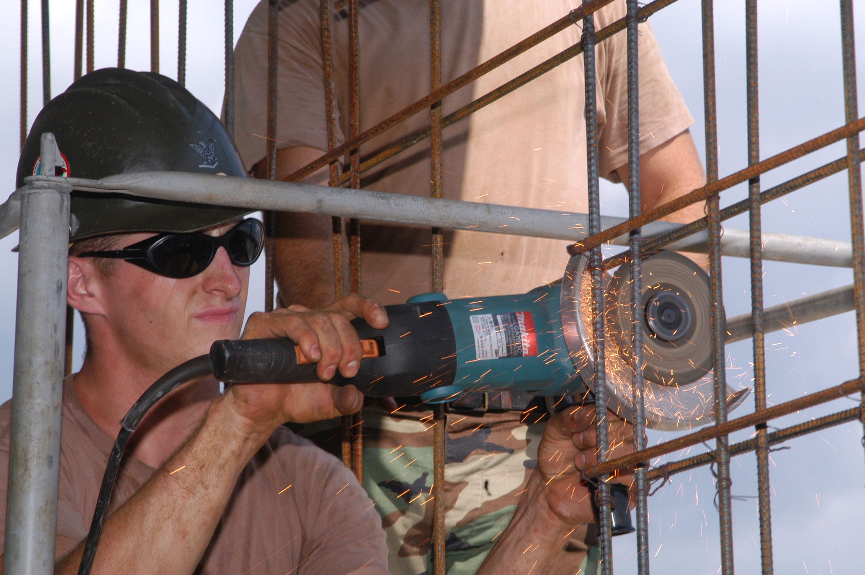US Navy 040914-N-2970T-029 Builder 3rd Class Mark Dyas, assigned to Naval Mobile Construction Battalion One Three Three (NMCB-133), Detail Sasebo, slices through a steel reinforcement bar
