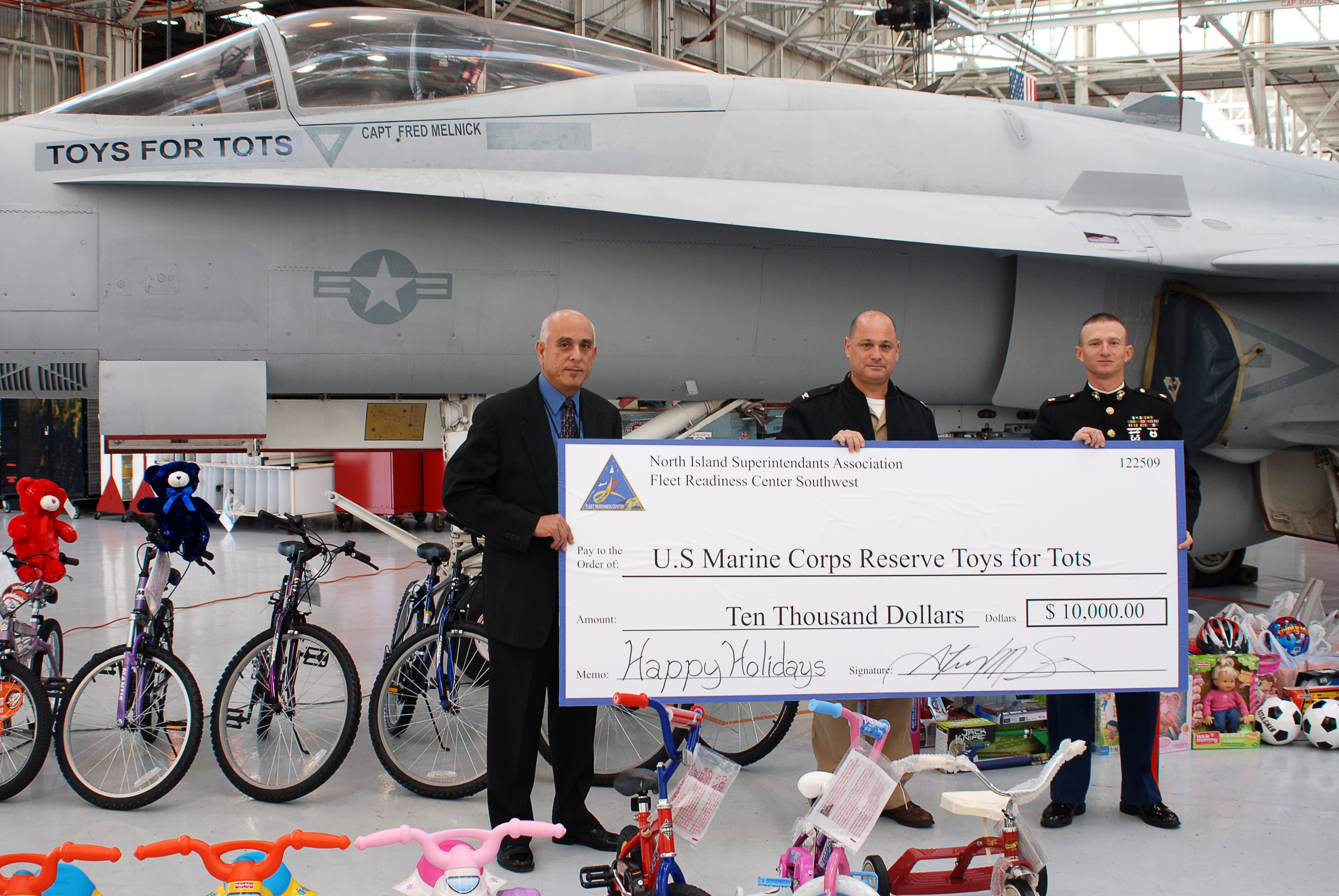 US Navy 091218-N-1878M-001 U.S. Marine Corps Reserves annual Toys for Tots campaign hold a ceremonial check representing a $10,000 donation by the employees of FRCSW during festivities