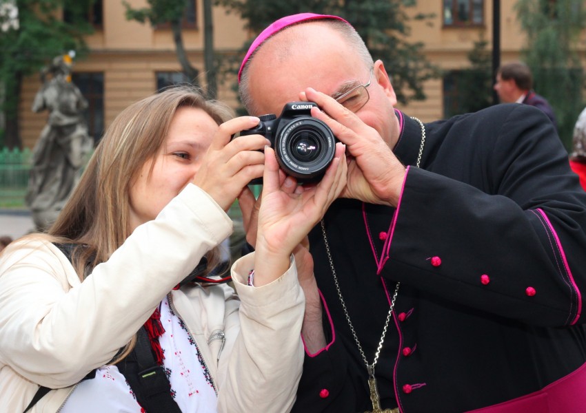 a protestant girl with a Catholic priest with a Canon camera