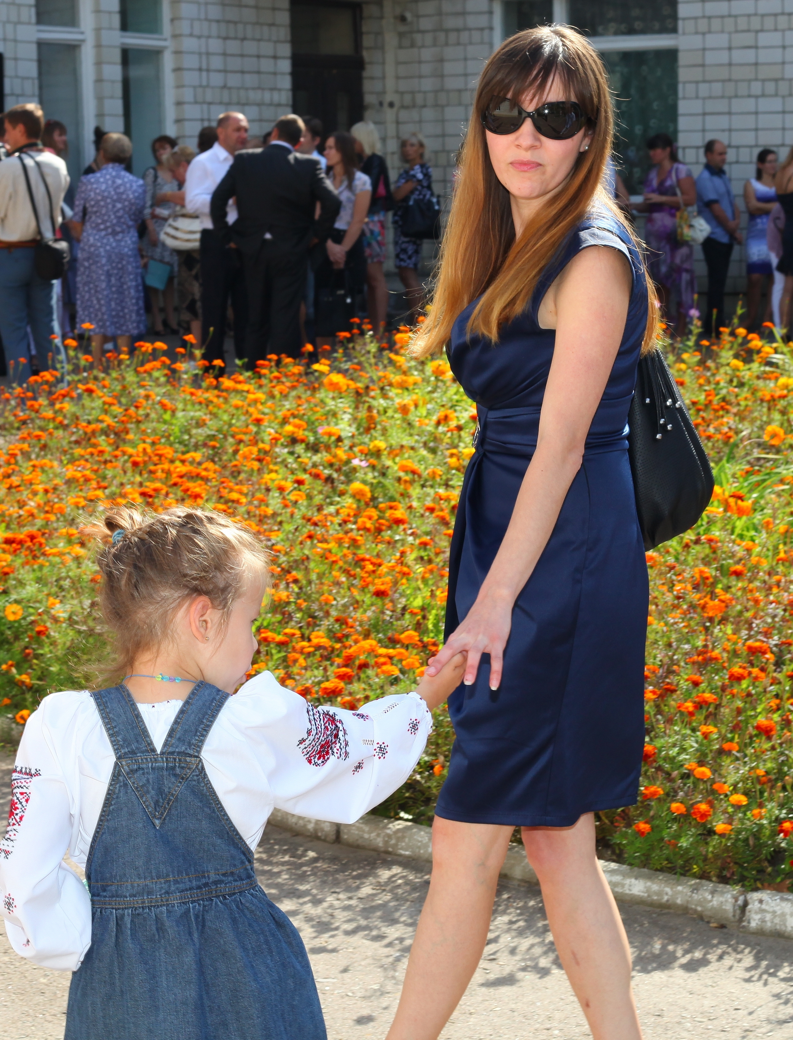 a beautiful young brunette woman in a dress and in sunglasses, with a child girl, photo 3