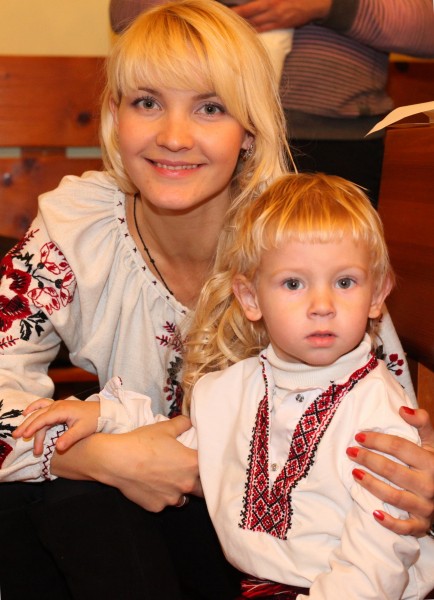 an amazingly tender and charming beautiful young blond Catholic woman with her son in a Church, photo 26