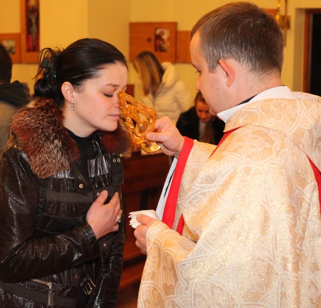 a beautiful young brunette Catholic woman in a Church kissing relics of a saint, photo 2