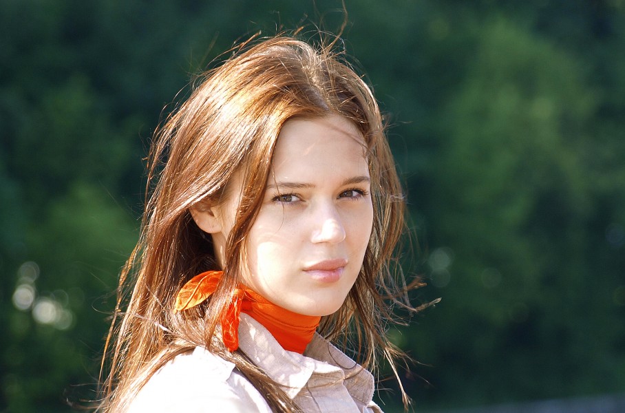 a woman with a light brown blouse and a red scarf
