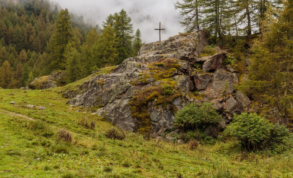 Wandeltocht rond Lago di Pian Palù (1800 m). in het Nationaal park Stelvio (Italië). Houten kruis boven op rots naast de bergweg 01