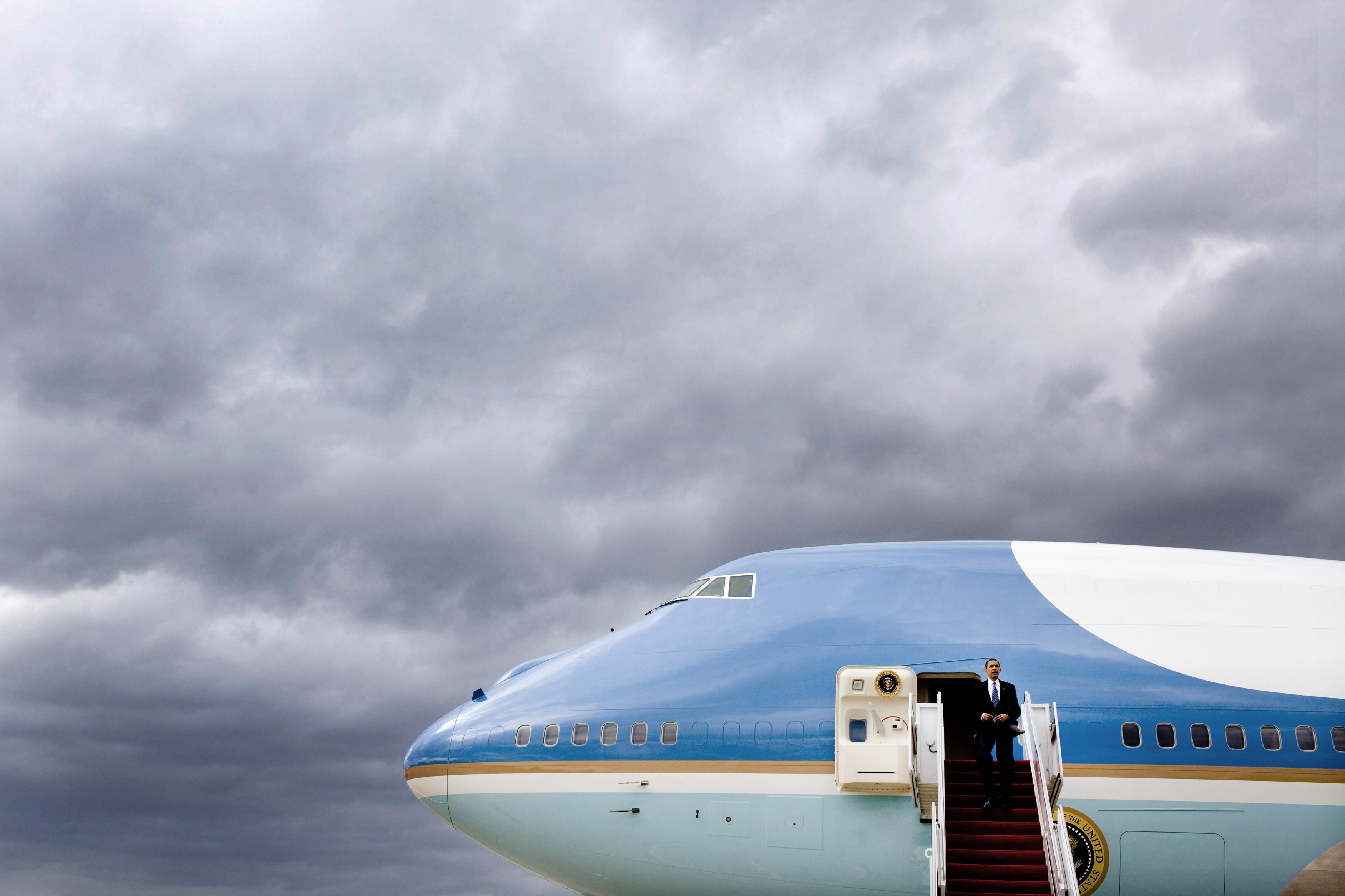 Barack Obama disembarks from Air Force One under a storm sky