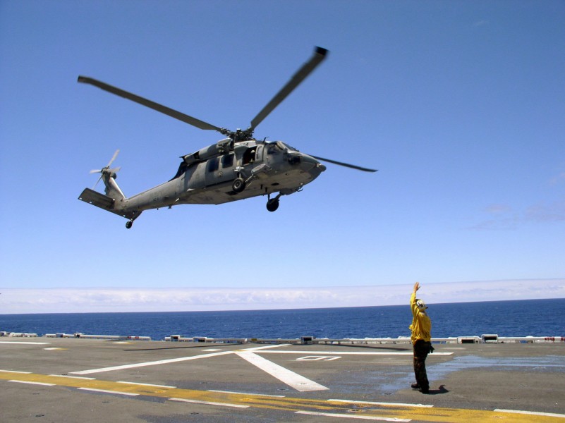 US Navy 040626-N-2379C-005 The Landing Signaling Enlisted (LSE), Aviation Boatswain's Mate 3rd Class Christina Duvall, directs a MH-60S Knighthawk assigned to the Gunbearers of HC-11 aboard the USS Tarawa