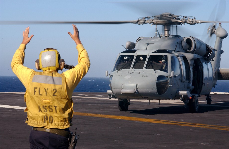 US Navy 040710-N-4757S-010 Aviation Boatswain's Mate 3rd Class Dustin Shipman signals to an MH-60S Nighthawk helicopter assigned to the Chargers of Helicopter Cargo Squadron Six (HC-6) during a vertical replenishment on the fli