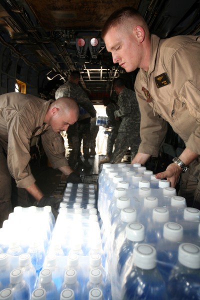 US Navy 071126-M-7696M-108 Cpl. Eric M. Dorfman, right, and Cpl. Nicholas M. Moneymaker load cases of bottled water onto a CH-53E Sea Stallion transport helicopter