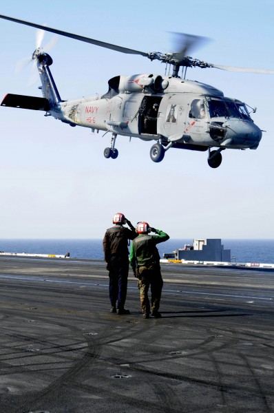 US Navy 100109-N-3038W-114 Sailors render a salute as an SH-60F Sea Hawk takes off from USS Nimitz (CVN 68)