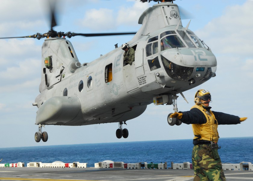 US Navy 110318-N-8607R-183 Aviation Boatswain's Mate Airman Daniel Moreno directs a CH-46E Sea Knight helicopter to take off from the flight deck o