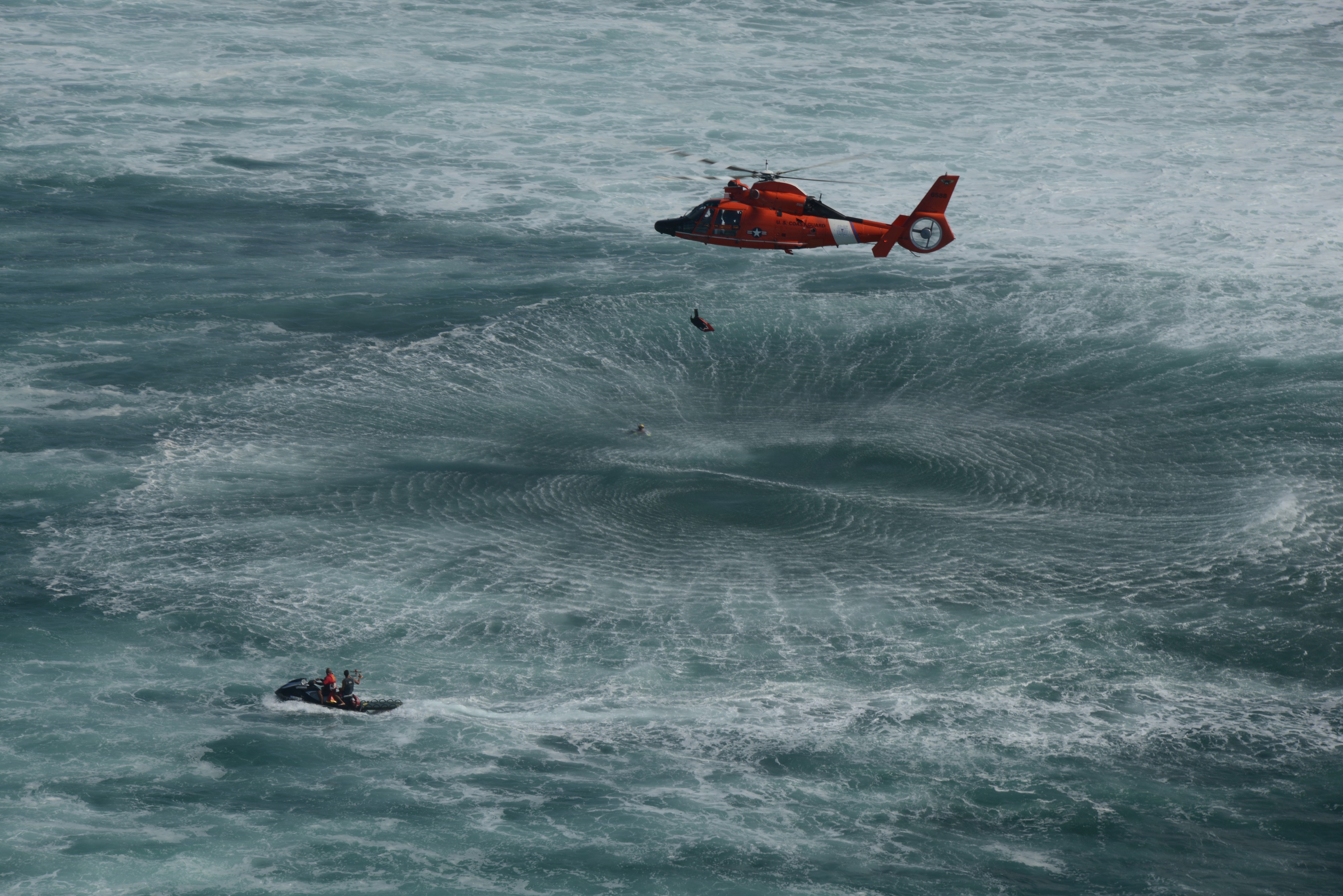 A U.S. Coast Guard MH-65 Dolphin helicopter with Air Station Barbers Point practices surf search and rescue techniques in Haleiwa, Hawaii, Jan. 18, 2013 130118-G-ZQ587-002