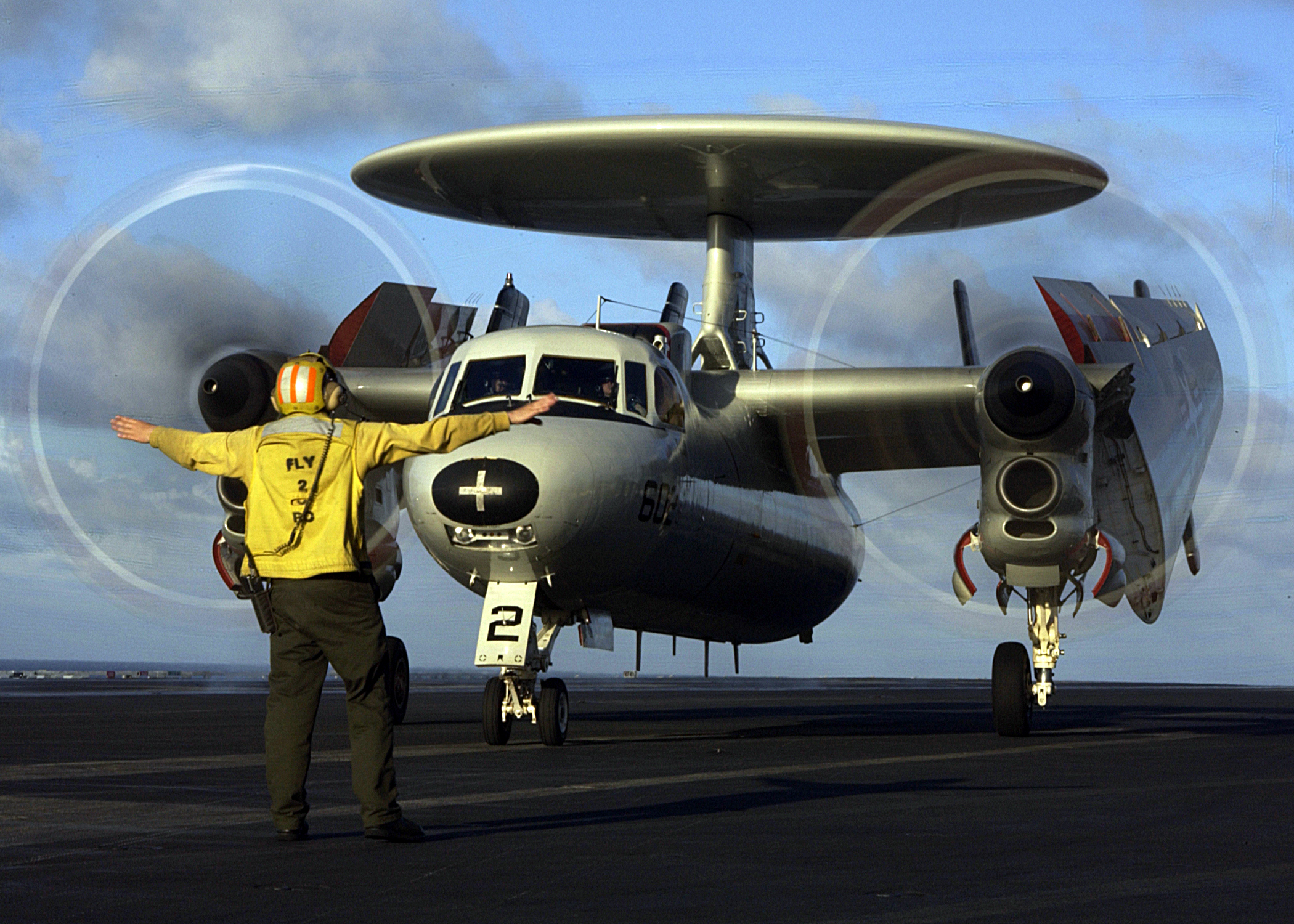 US Navy 050218-N-3241H-012 An Aviation Boatswain's Mate directs the pilots of an E-2C Hawkeye after a safe recovery during flight operations aboard the Nimitz-class aircraft carrier USS Carl Vinson (CVN 70)