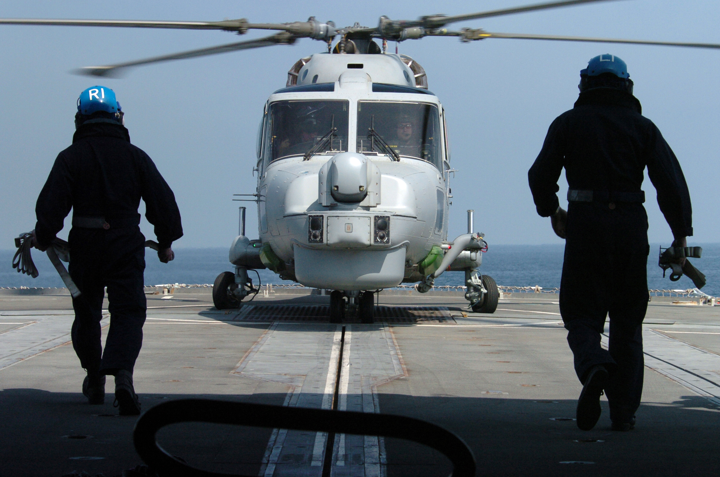 US Navy 050220-N-1444C-038 Two Royal Navy Sailors prepare to chain-down a Royal Navy Lynx Mk8 helicopter, assigned to 815 Squadron aboard the Royal Navy Type 23 frigate HMS Grafton (F80)