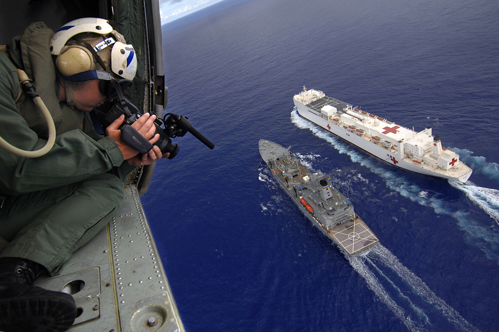 US Navy 060516-N-6501M-029 Photographer's Mate 2nd Class Gregory E. Badger videotapes an underway-replenishment operation between the Military Sealift Command (MSC) hospital ship USNS Mercy (T-AH 19) and the MSC replenishment