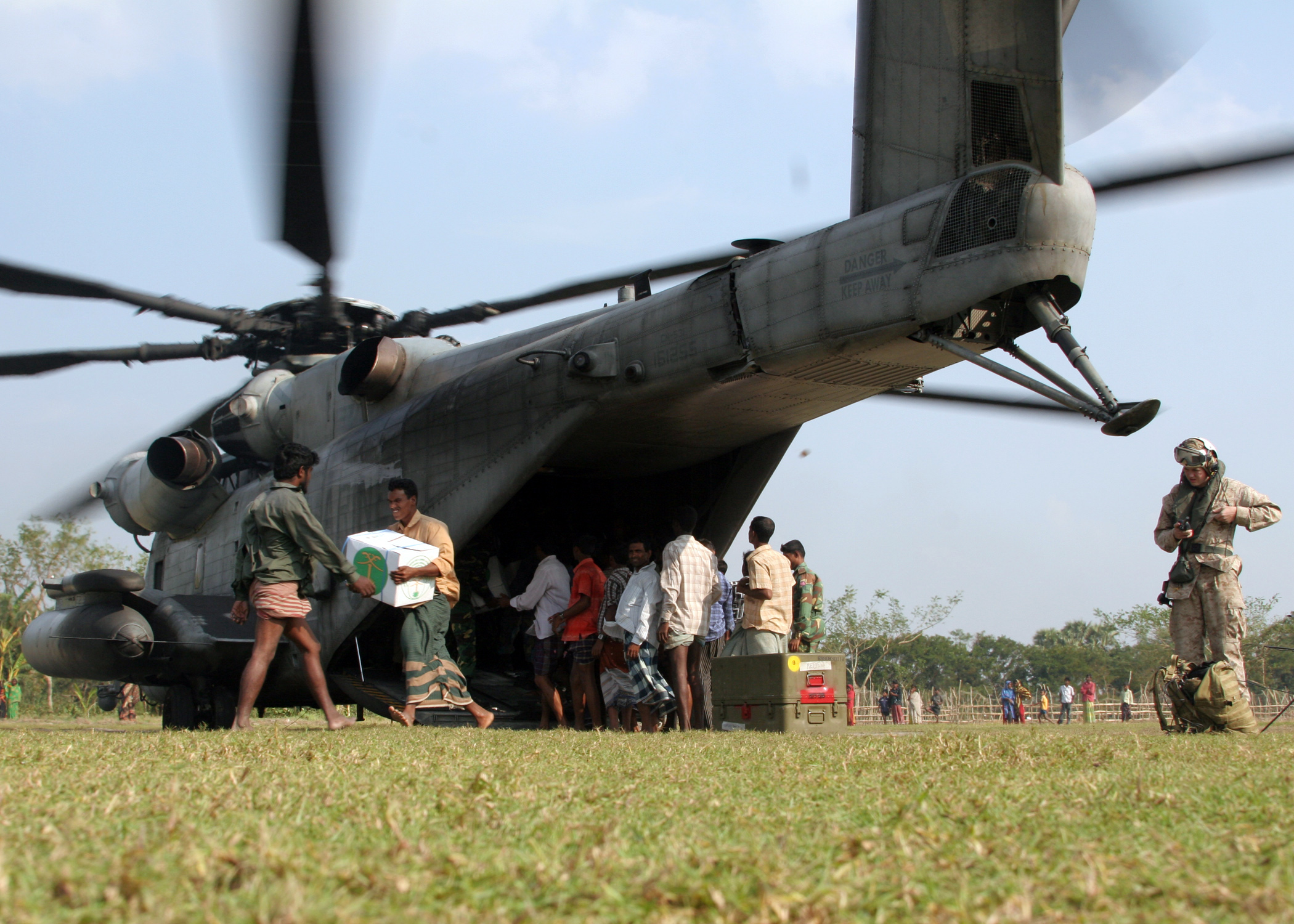 US Navy 071201-M-3095K-140 angladeshi locals off-load food and supplies from a CH-53E Super Stallion