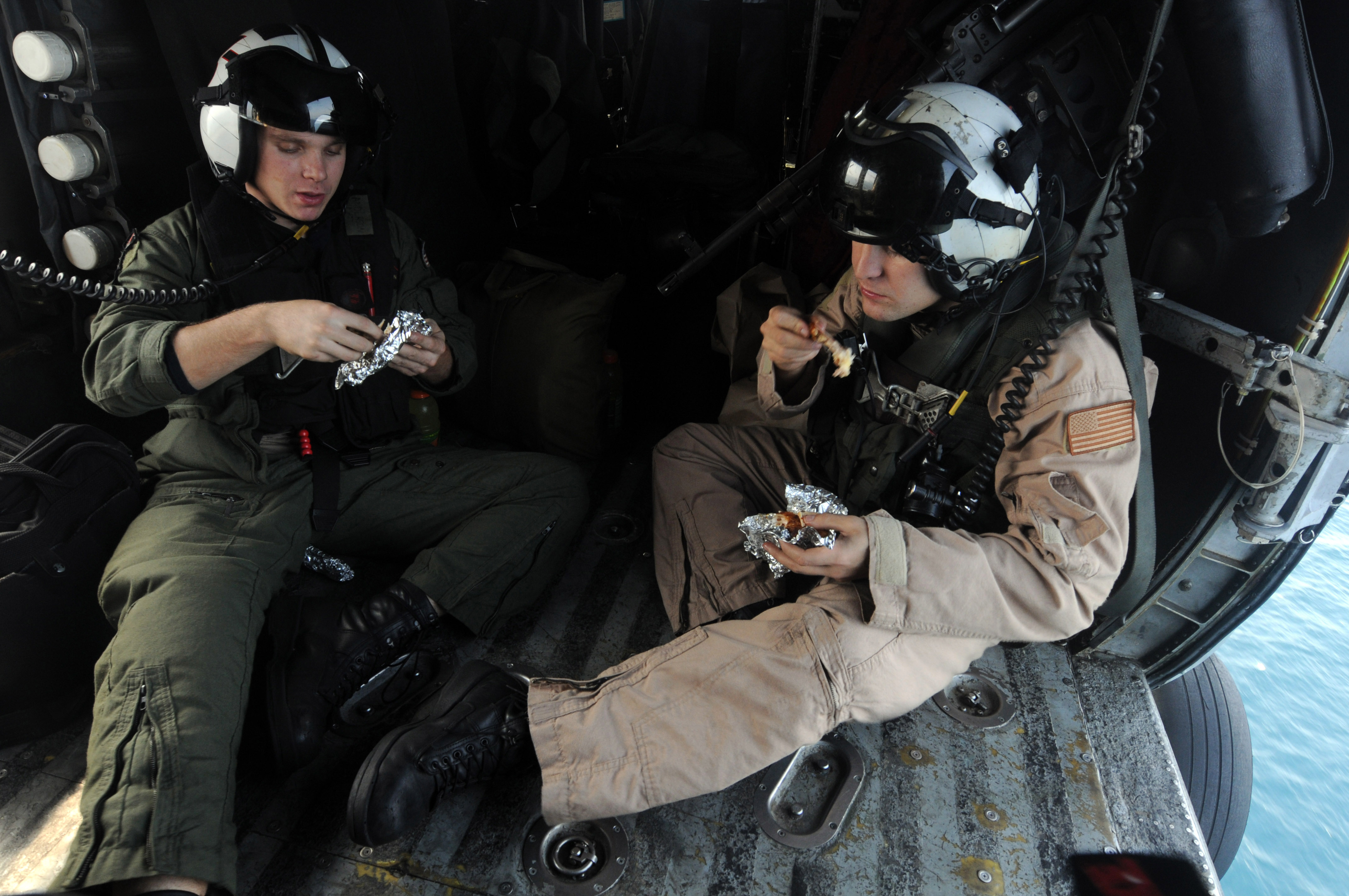 US Navy 081013-N-3659B-018 Aviation Warfare Systems Operator 3rd Class Matthew Anderson, left, and Aviation Warfare Systems Operator 2nd Class Adam Walker take a moment to eat their lunches in an HH-60H Sea Hawk