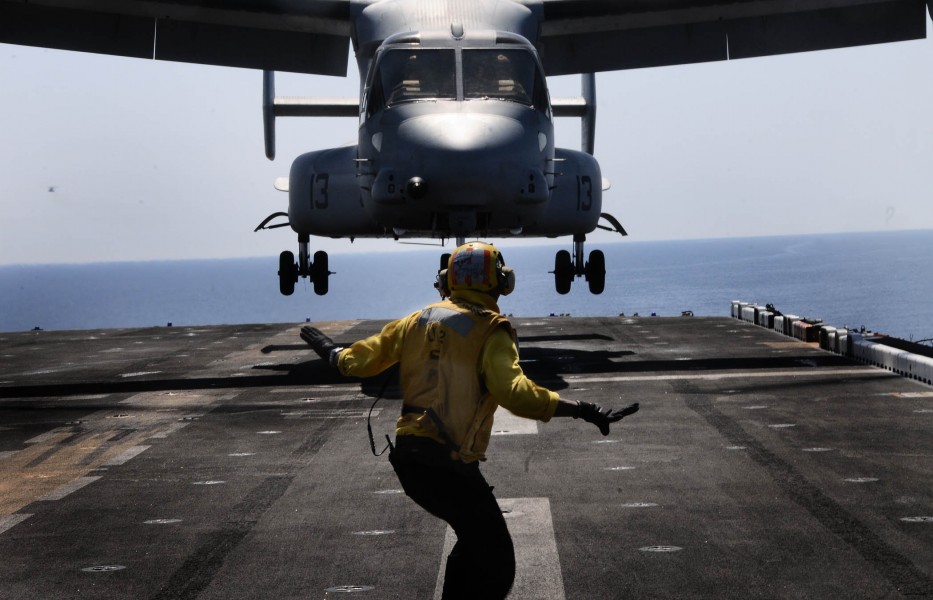 Defense.gov News Photo 110511-N-7508R-002 - A landing signal enlisted assigned to the multipurpose amphibious assault ship USS Bataan LHD 5 guides an MV-22B Osprey assigned to Marine Medium