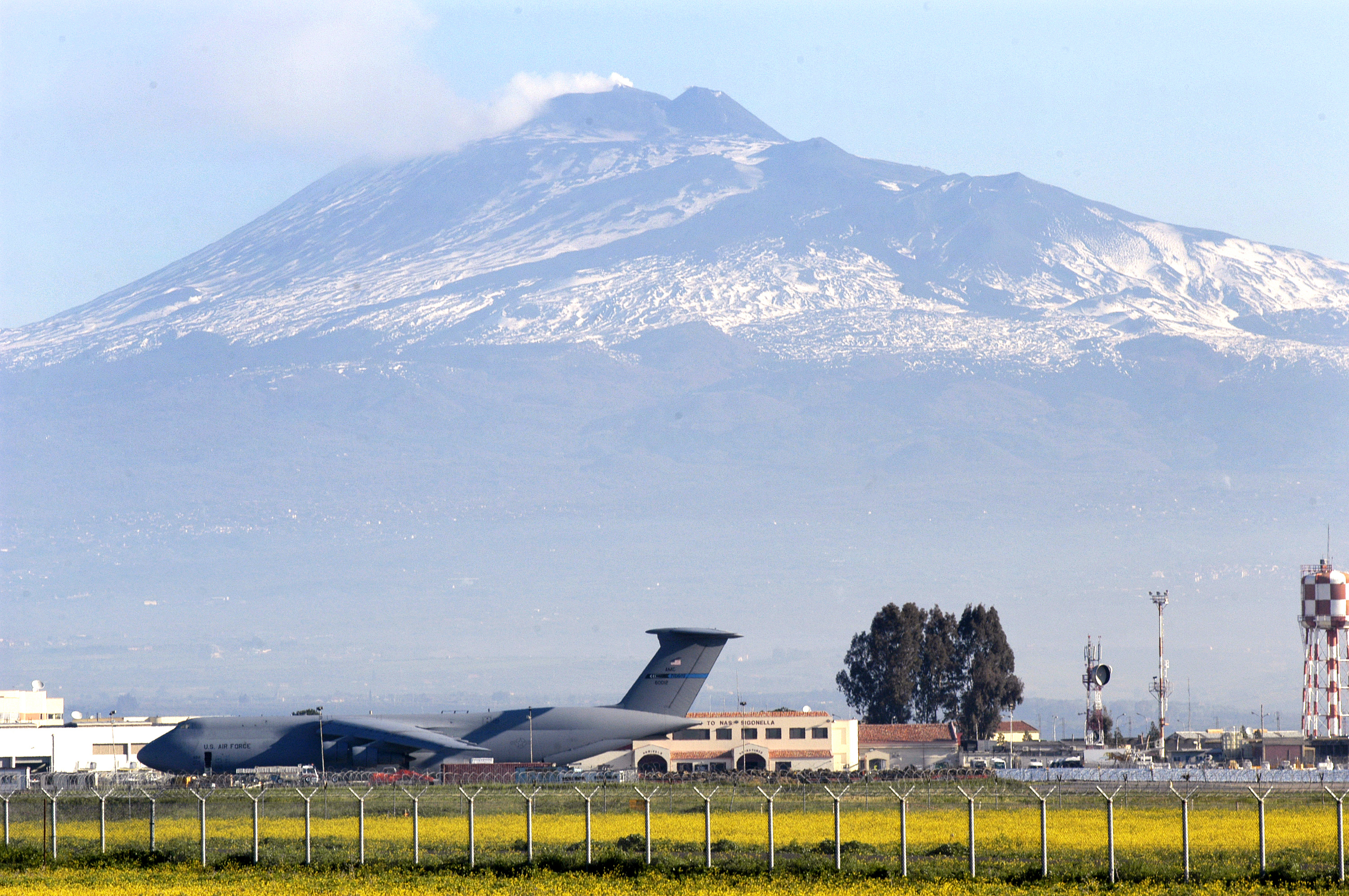 US Navy 030325-N-9693M-001 Sicily's volcano, Mt. Etna, is the backdrop for a U.S. Air Force C-5 and the air terminal of Naval Air Station (NAS) Sigonella