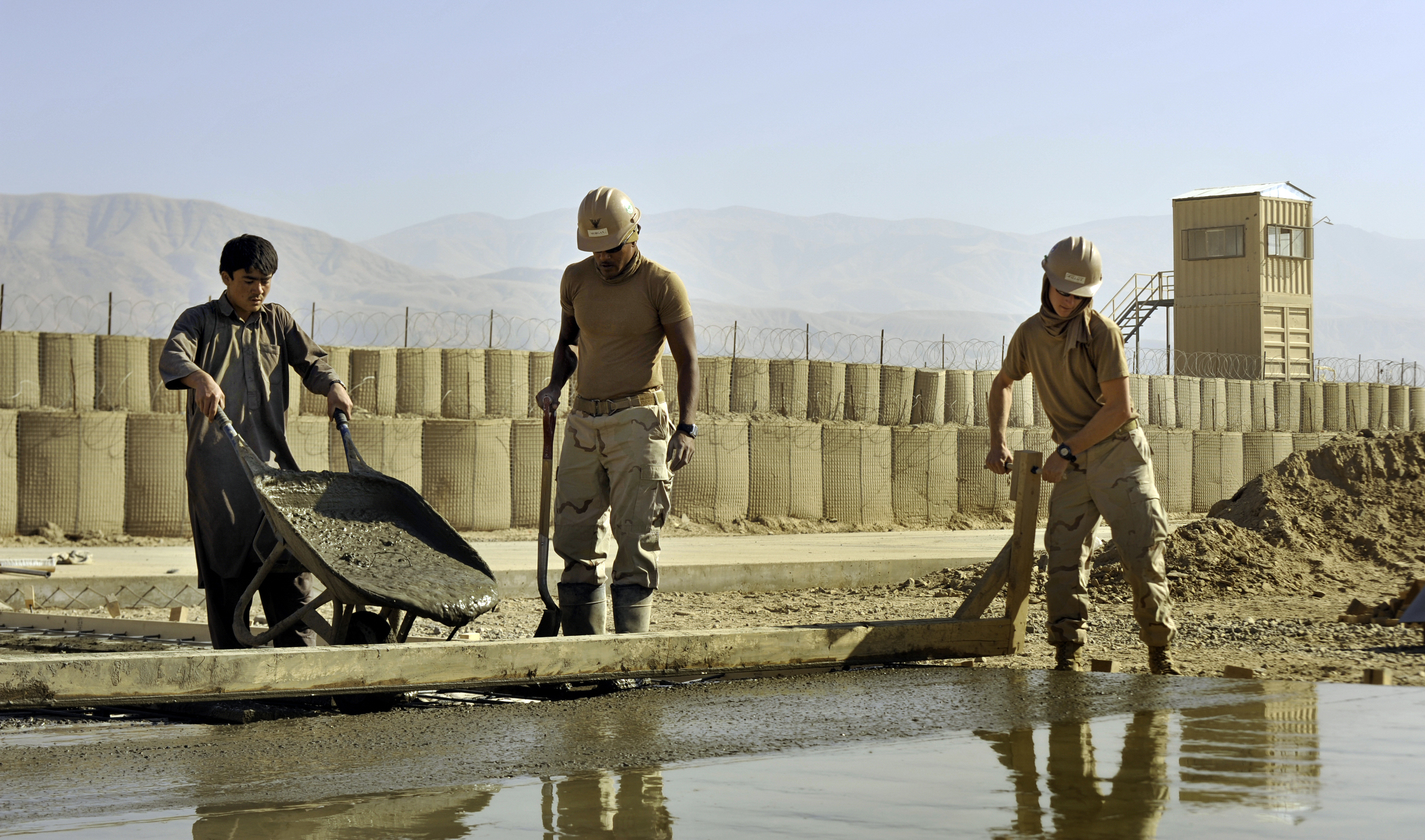 US Navy 101123-N-6436W-070 Seabees assigned to Naval Mobile Construction Battalion (NMCB) 40 work with Afghani contractors to place concrete for he