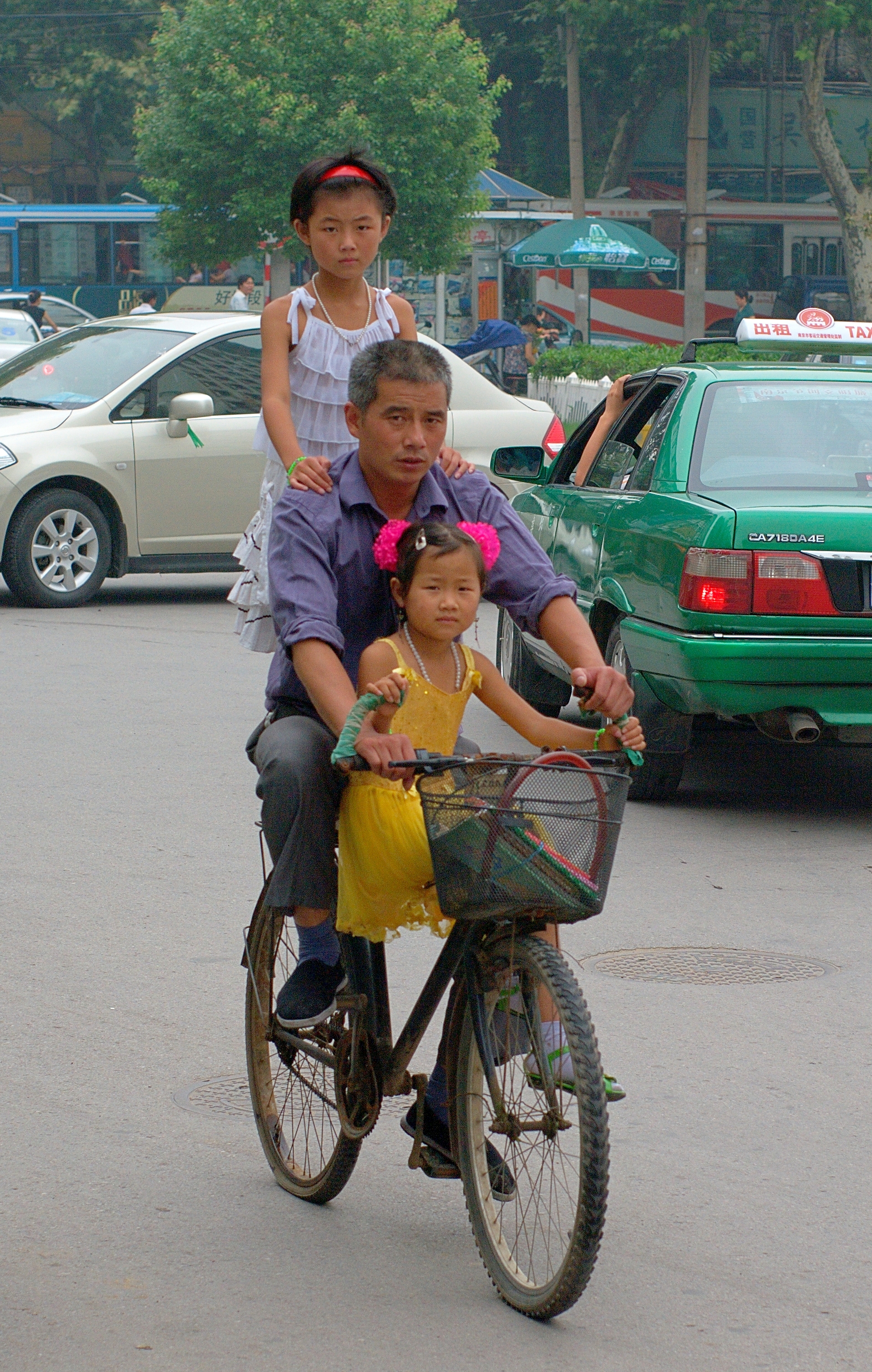 Man Riding a bike with two kids