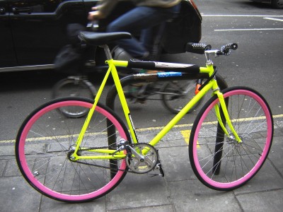 Brightly coloured fixed wheel bicycle with Velocity coloured rims, Tottenham Court Road, London.
