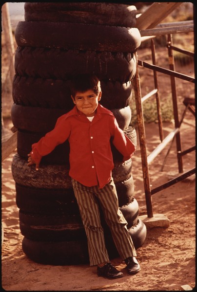 NAVAHO BOY LEANS AGAINST TOWER OF DISCARDED TIRES. LACK OF DISPOSAL FACILITIES IS A COMMON PROBLEM IN REMOTE AREAS OF... - NARA - 544357