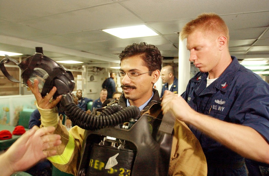 US Navy 020924-N-4309A-030 Damage Controlman assists with the firefighting gear of Pakistani Lieutenant from the Pakistani ship Tippu Sultan (DDG 185)