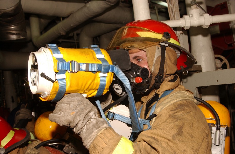 US Navy 021104-N-0685W-002 Damage Controlman during a General Quarters (GQ) drill, checks a space for fire using a hand held thermal Imager