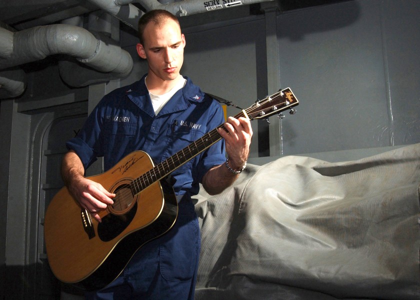 US Navy 021201-N-6817C-001 Sailor enjoys playing his guitar during some leisure time aboard the aircraft carrier USS Abraham Lincoln (CVN 72)