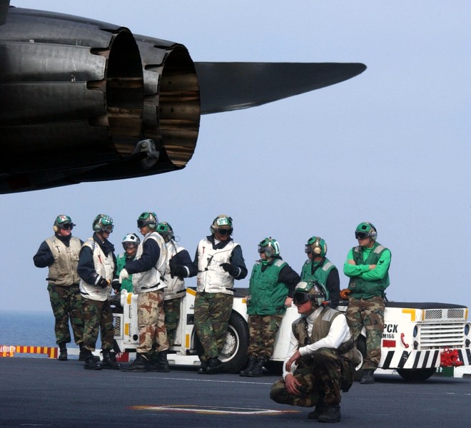 US Navy 030325-N-9060G-021 Flight deck personnel stand by as an F-A-18 Hornet is prepared to launch