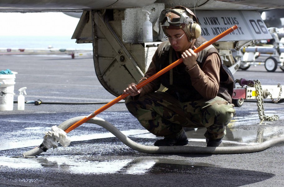 US Navy 030414-N-9319H-005 Airman Apprentice Jimmy Zayas from San Antonio, Texas, vacuums out water from a pad eye