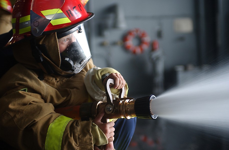 US Navy 031018-N-8295E-319 Rachel Vata, from Superior, Colo., mans a fire hose during a damage control demonstration held in the USS Ronald Reagan (CVN 76) hangar bay