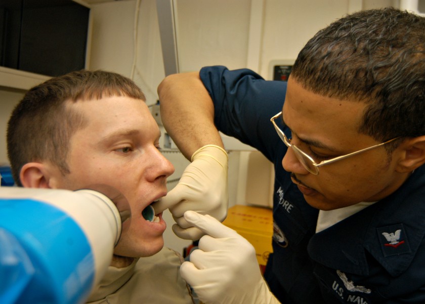 US Navy 040421-N-6293B-001 Dental Technician 3rd Class Kenneth Moore, of South Port N.C., prepares to X-ray the mouth of Cryptologic Technician 3rd Class Scott Bohan, of Kansas City, Mo